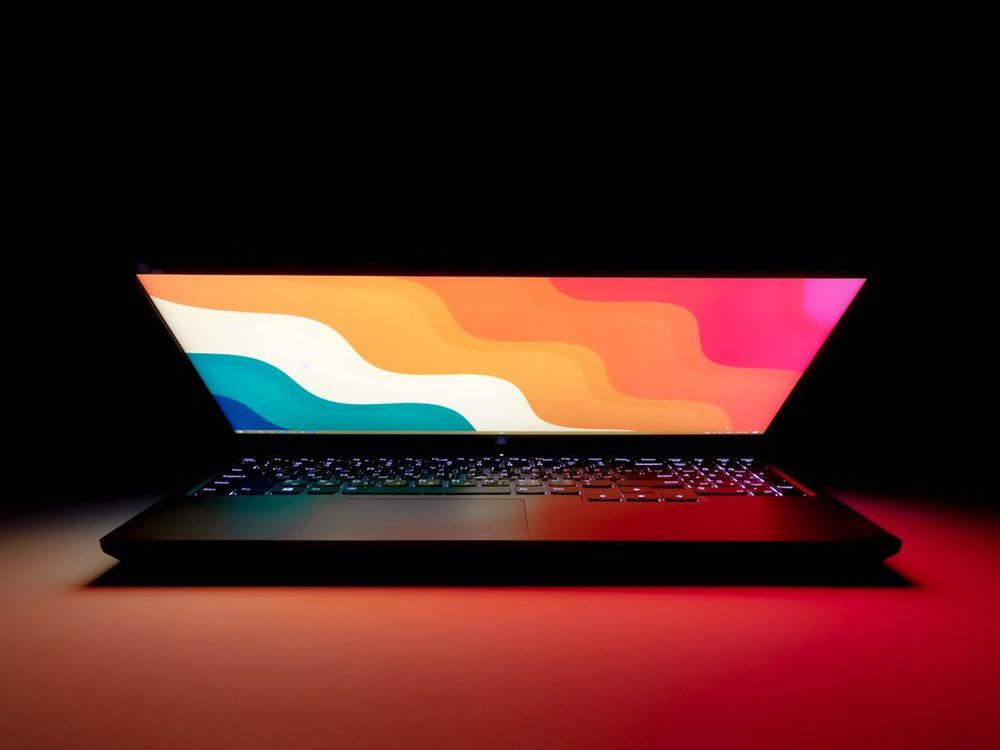 An open laptop glowing in a dark room
